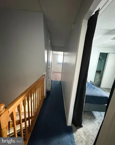 a view of a hallway with wooden floor and stairs