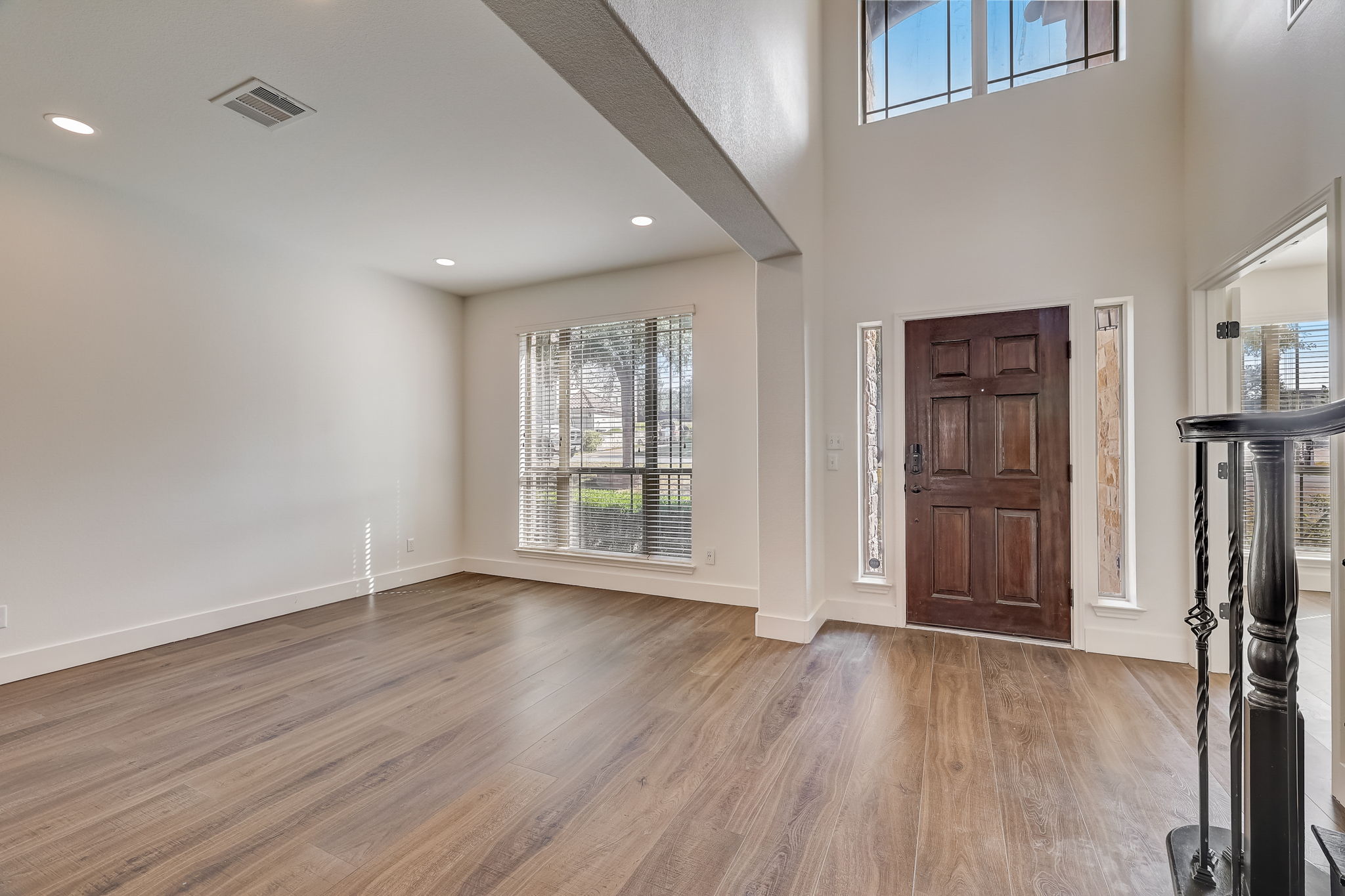 16012 Spillman Ranch Loop Austin, TX 78738 - Photo 7 of 38 A striking entry with a rich wooden door welcomes you into this home, showcasing lofty ceilings and elegant wood flooring.