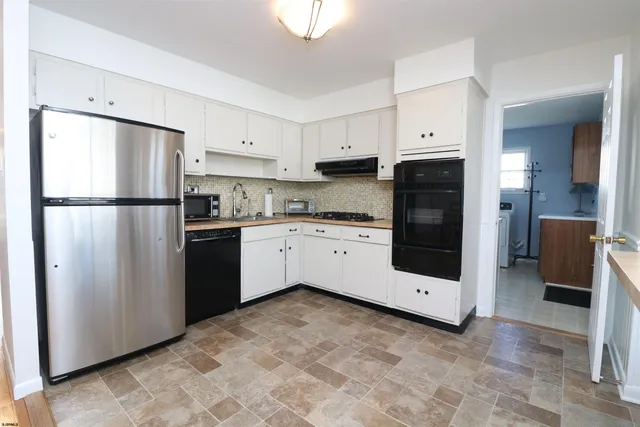 a kitchen with white cabinets and white stainless steel appliances