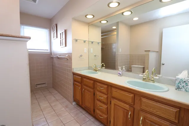 a bathroom with a double vanity sink a mirror and a shower