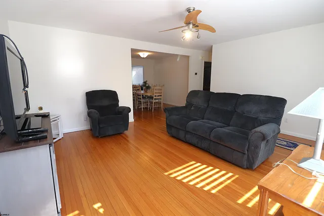 a living room with furniture a ceiling fan and a rug