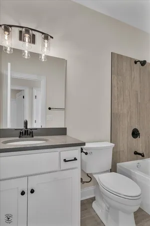 a bathroom with a granite countertop sink mirror vanity and toilet