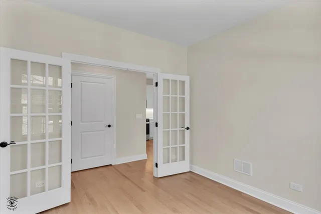 a view of empty room with wooden floor and cabinet