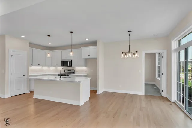 a kitchen with stainless steel appliances kitchen island a sink and a refrigerator