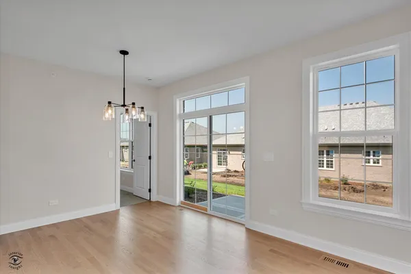 a view of empty room with window and wooden floor