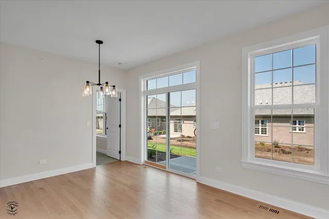 a view of empty room with window and wooden floor