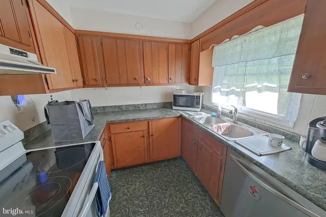 a kitchen with stainless steel appliances granite countertop a sink stove and cabinets