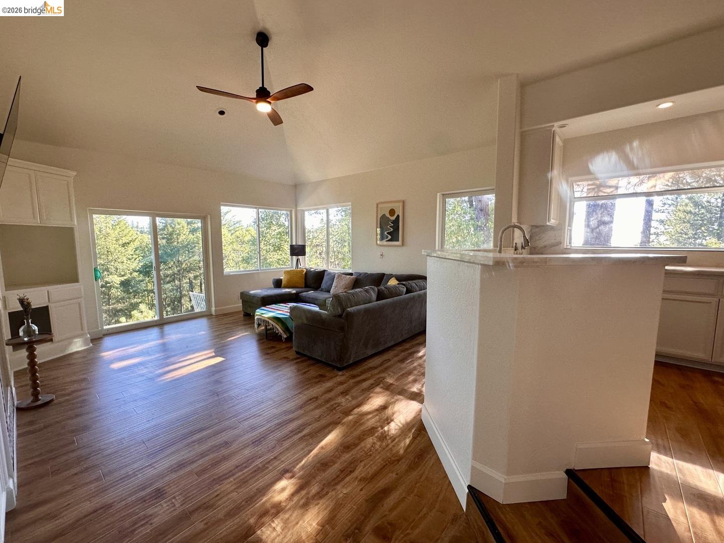 2080 Nelson Road Camino, CA 95709 - Photo 12 of 55 Vaulted ceiling with a ceiling fan, wood-finish flooring, built-in cabinetry, sliding glass doors, and a kitchen island with a sink and faucet