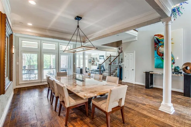 a dining room with wooden floor a chandelier a wooden table and chairs