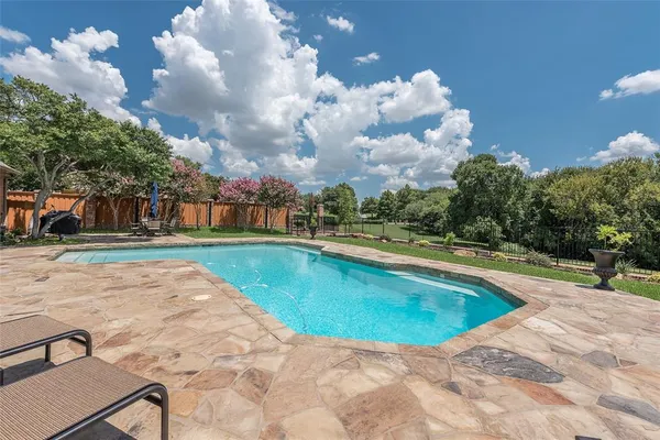 a view of swimming pool is middle in the garden