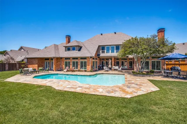 a view of a house with a yard table and chairs under an umbrella