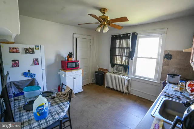 a kitchen with stainless steel appliances granite countertop a refrigerator a sink dishwasher a stove and a dining table with wooden floor