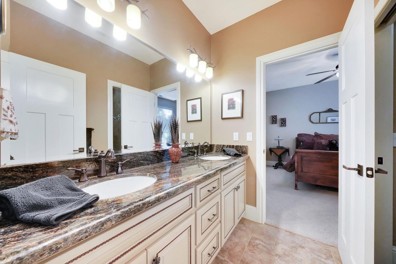 11195 Vintage Road Ione, CA 95640 - Photo 11 of 92 a en suite bathroom with a granite countertop sink and a mirror