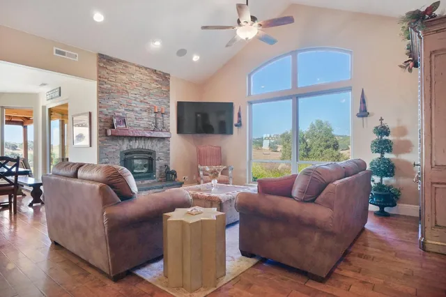 a living room with furniture a flat screen tv and a large window