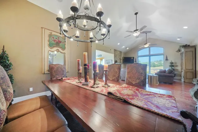 a living room with furniture kitchen view and a chandelier