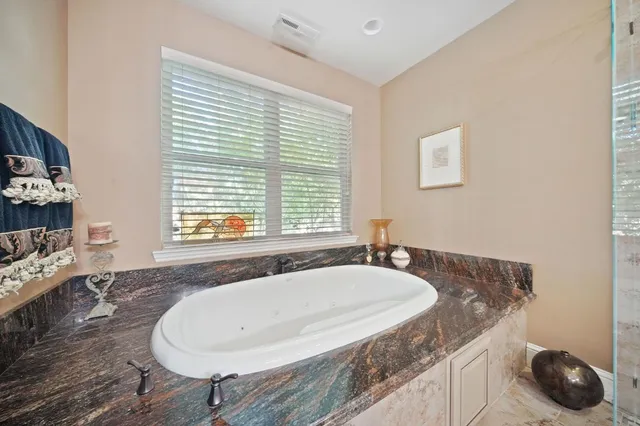 a spacious bedroom with a bed a table and painting on the wall