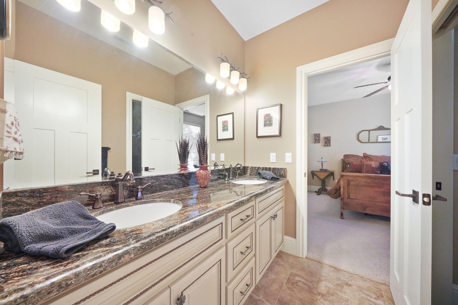 11195 Vintage Road Ione, CA 95640 - Photo 66 of 92 a en suite bathroom with a granite countertop sink and a mirror