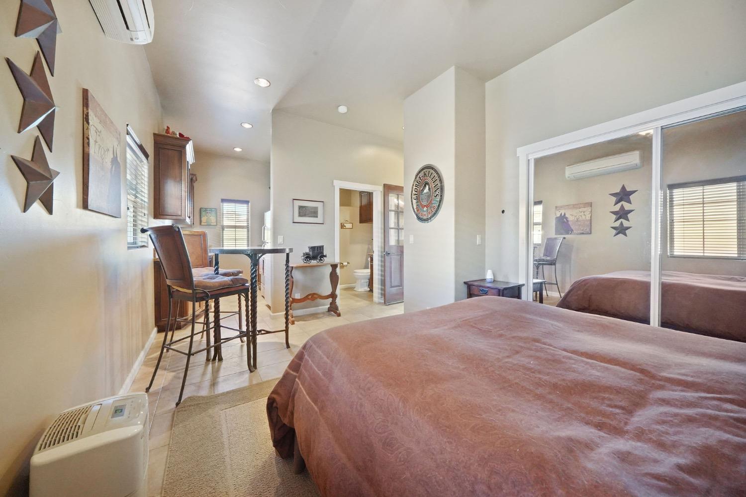11195 Vintage Road Ione, CA 95640 - Photo 85 of 92 a spacious bedroom with a bed a table and painting on the wall