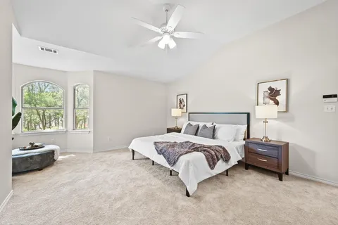 a spacious bedroom with a bed and a window