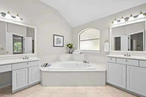 a bathroom with a bathtub sink and mirror