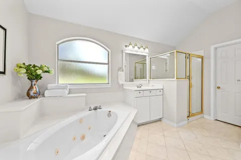 an empty room with windows and chandelier fan