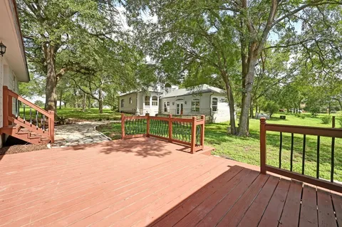 a view of a balcony with wooden floor and fence and a floor to ceiling window