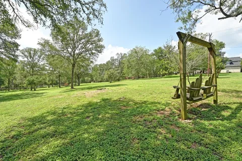 an empty room with windows and chandelier fan
