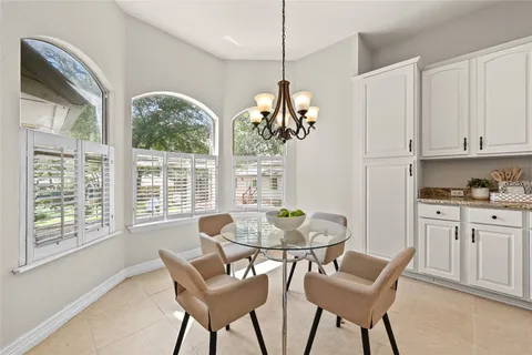 a dining room with furniture a chandelier and wooden floor