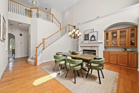 a dining room with furniture a rug a fireplace and a chandelier