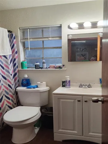 a bathroom with a toilet a sink and a window