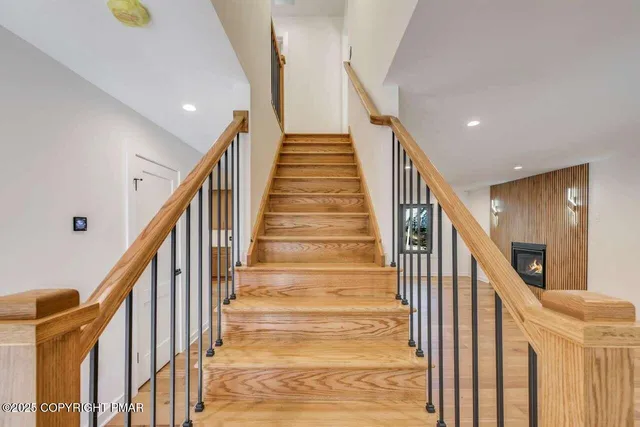 a view of staircase with lots of frames on wall and a wooden floor