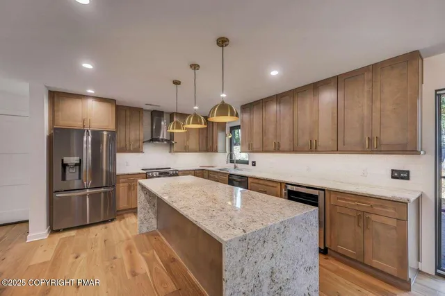 a kitchen with a refrigerator a sink and wooden floor