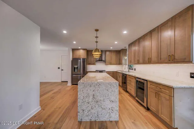 a large kitchen with stainless steel appliances granite countertop a sink a stove and a refrigerator