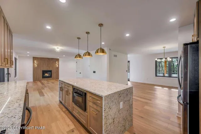 a large kitchen with stainless steel appliances granite countertop a large counter top and a wooden floors