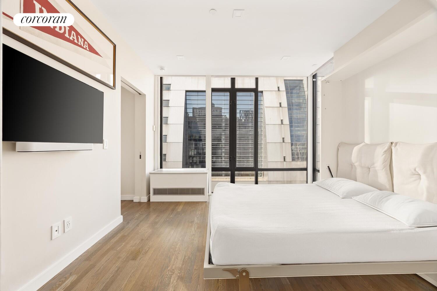 148 East 24th Street, Unit 15A Manhattan, NY 10010 - Photo 12 of 14 a large white bed in a hotel room next to a window