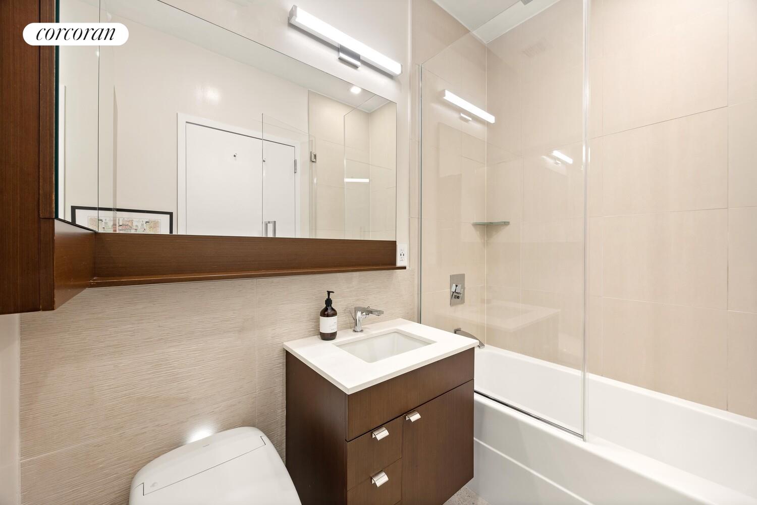 148 East 24th Street, Unit 15A Manhattan, NY 10010 - Photo 13 of 14 a bathroom with a sink a toilet and a mirror