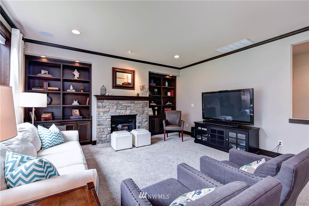 4410 220th Street Southeast Bothell, WA 98021 - Photo 11 of 28 a living room with furniture a flat screen tv and a fireplace