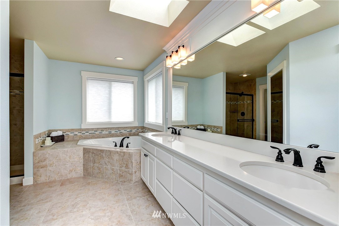 4410 220th Street Southeast Bothell, WA 98021 - Photo 19 of 28 a spacious bathroom with a bathtub a double vanity sink and mirror