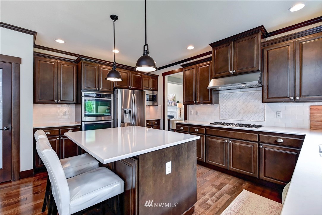 4410 220th Street Southeast Bothell, WA 98021 - Photo 10 of 28 a kitchen with stainless steel appliances granite countertop a sink a stove and a refrigerator