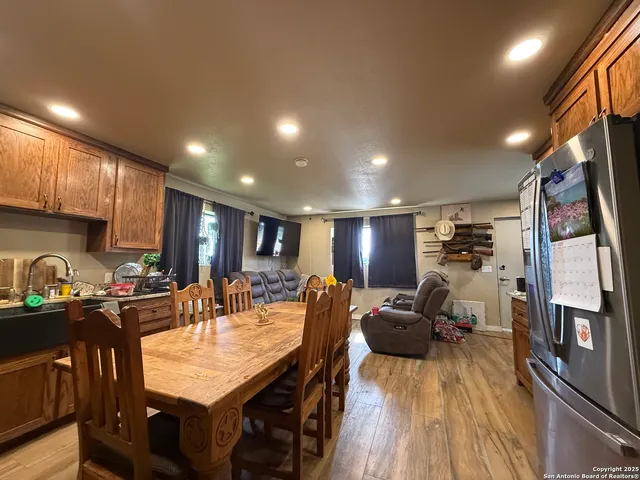 a view of a dining room with furniture a kitchen and chandelier