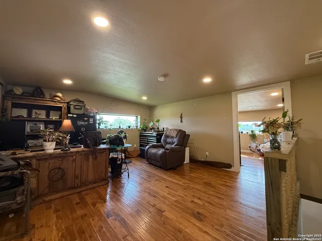 a living room with furniture a wooden floor and a sink