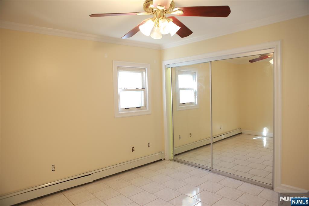 2 Harvey Avenue, Unit A Rochelle Park, NJ 07662 - Photo 20 of 25 a view of an empty room with window and chandelier fan