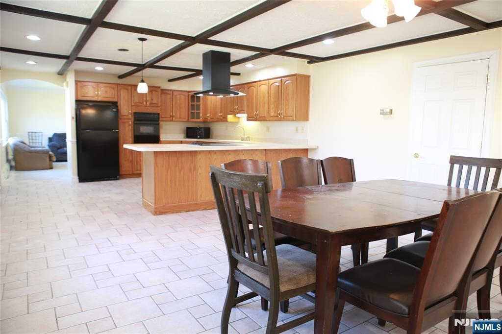 2 Harvey Avenue, Unit A Rochelle Park, NJ 07662 - Photo 3 of 25 a dining room with stainless steel appliances kitchen island granite countertop a table chairs and granite counter tops