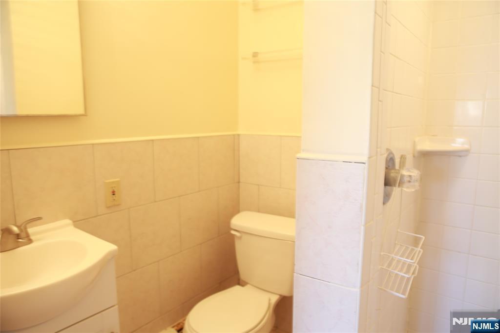 2 Harvey Avenue, Unit A Rochelle Park, NJ 07662 - Photo 8 of 25 a white toilet sitting next to a bathroom sink