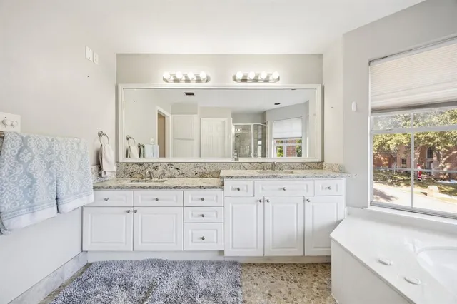 a spacious bathroom with a granite countertop sink and a mirror