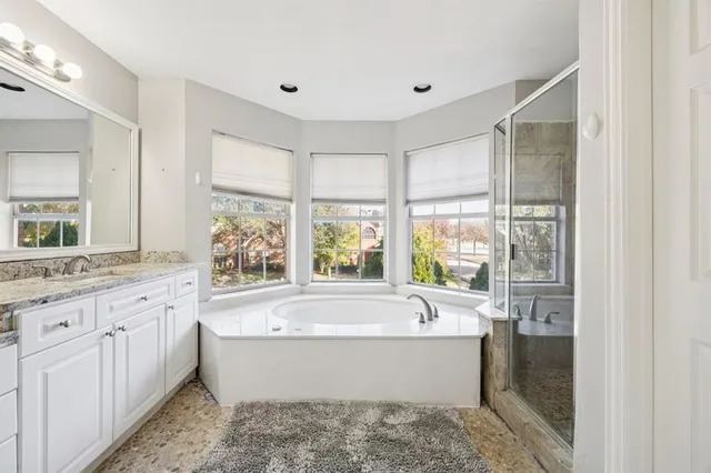 a bathroom with a large tub sink and double vanity