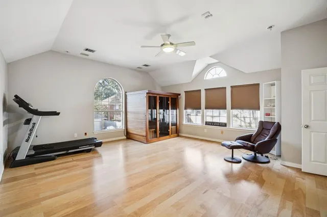 a living room with furniture gym equipment and a large window