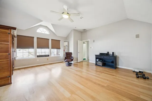 a view of a livingroom with wooden floor and a ceiling fan