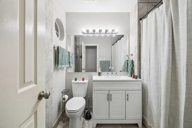 a bathroom with a toilet sink and mirror
