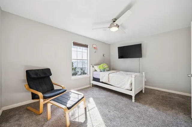 a bedroom with a bed window and a chair